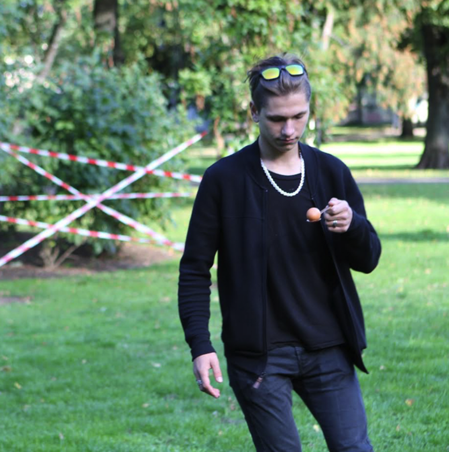 A youth navigates an obstacle course with an egg on a spoon.